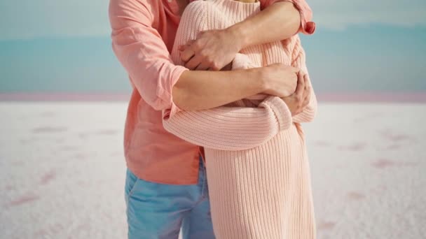 Camera lifting along man and woman hugging and tenderly touching each other on white desert or beach — Stock Video