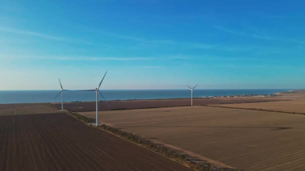 Duży widok z lotu ptaka. turbiny wiatrowe na polach rolniczych jesienią słoneczny poranek — Wideo stockowe