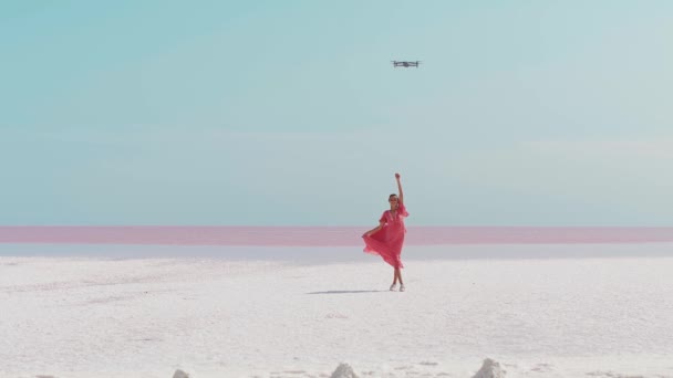 Mujer romántica en vestido rosa posando para drone quadcopter en hermoso paraíso paisaje — Vídeo de stock