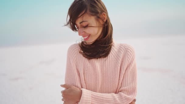 Close up retrato mulher bonita em suéter de malha rosa na bela paisagem da natureza, parece deserto branco — Vídeo de Stock