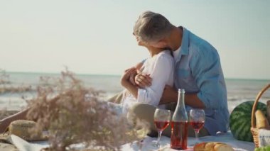 Sevecen genç aile çifti mutlu karı koca rahat piknik battaniyesine oturur şarap, meyve, ekmek sepeti.