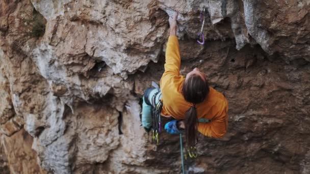 Hombre deportivo escalador escalando en la ruta de la roca, haciendo un movimiento duro y cortando la cuerda — Vídeos de Stock