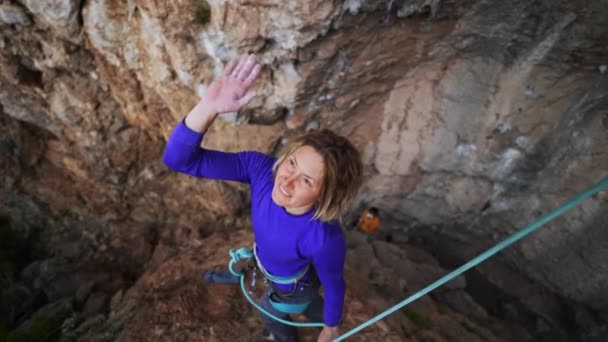 Vidám nő hegymászó ad pacsit sikeres mászás után az útvonal a sziklán — Stock videók