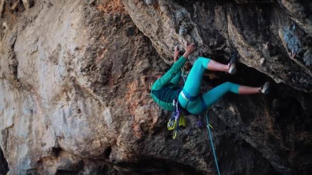 Mujer fuerte escalador escalada dura dura ruta de roca en acantilado negro muy sobresaliente en Turquía. — Vídeos de Stock