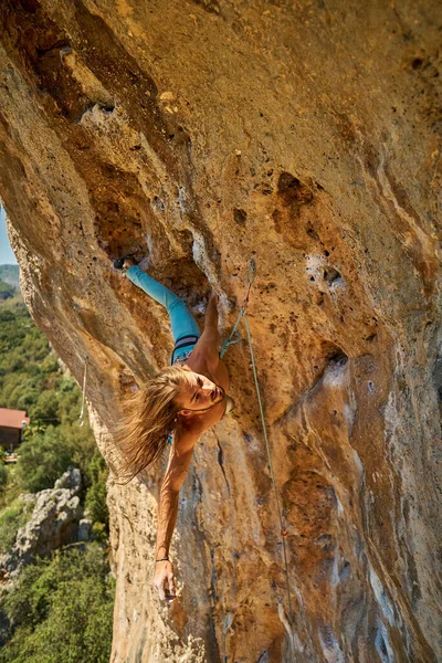 Man climber climbing on rock cliff, making acrobatic dangerous upside down move. — Stock Photo, Image