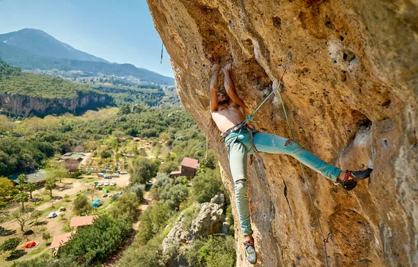 Seitenansicht starker Mann klettert auf Felswand mit wunderschönen Bergen Blick auf die Natur — Stockfoto