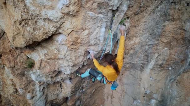 In Zeitlupe klettert ein athletischer männlicher Bergsteiger auf eine überhängende Felswand. Mann unternimmt schwierige Anstrengungen und bewegt sich. — Stockvideo