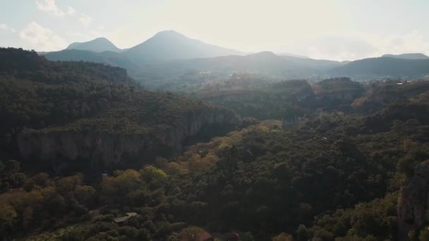 Aerail drone άποψη από ψηλά στο μεγάλο φυσικό ηλιοβασίλεμα φόντο με βουνά, σπηλιές, βράχια και δάση και κάμπινγκ — Αρχείο Βίντεο
