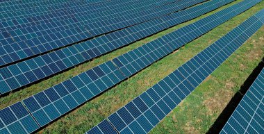Yeşil alandaki güneş enerjisi panellerinin havadan görünüşü temiz ekolojik enerji üretiyor.
