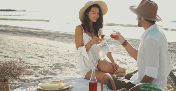 Romantisk par som drikker vin og nyter piknik på stranden, feirer jubileumsforhold – stockfoto