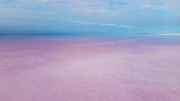 背景に風力発電所と曇りの日の出でカラフルなピンクの湖の滑らかな表面. — ストック動画