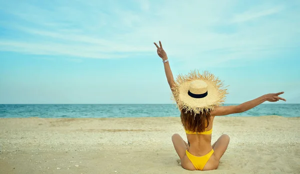 Rückseite fröhliche Frau sitzt am Strand und genießt Kurzurlaub — Stockfoto