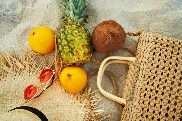 Top ver ropa de moda femenina de verano y fruta tropical plana yacía en la arena — Foto de Stock
