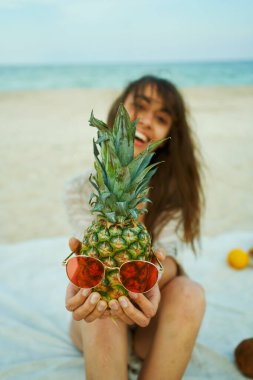 Ananaslı komik kukla kafası pembe güneş gözlüklü kadın ellerinde.