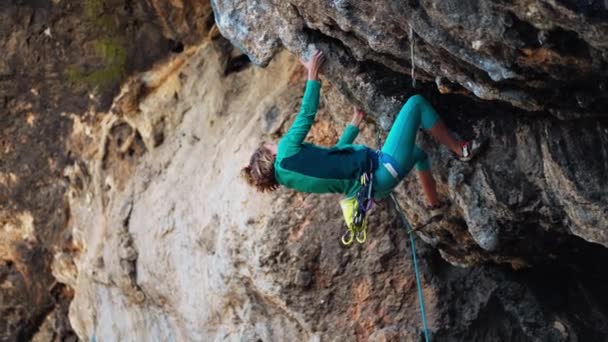 Femme forte escaladeur grimpe dur dur route rocheuse sur très surplombant falaise noire en Turquie. — Video