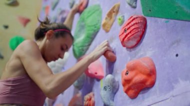 Alttan bakan sporcu kadın spor salonuna tırmanıyor, sıkı tutunuyor. Spor, spor, aktif yaşam tarzı.