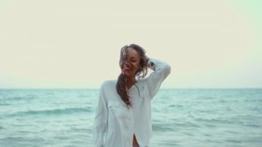 Deniz suyunda dalgalarla yürüyen güzel bir yaz kadını. Özgürlük ve cennet kavramı