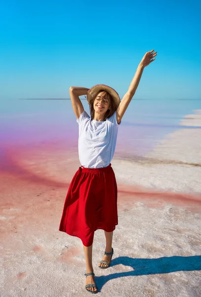 Stilig sommerjente som liker å gå ved en lys rosa innsjø, sommereventyr som reiser – stockfoto