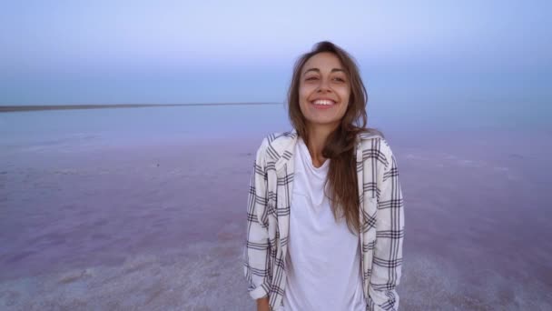 Щаслива радісна жінка насолоджується пейзажем природи на рожевому солоному озері ввечері — стокове відео