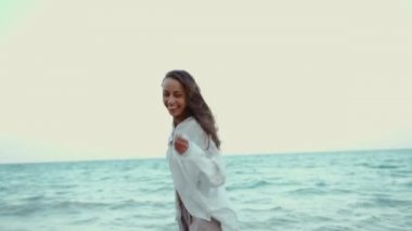 Hareket portresi gülen kadın el ele tutuşan erkek arkadaş ve vahşi plajda dönen.