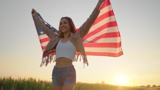 Amerikaanse vrouw trots houden Amerikaanse vlag bij zonsondergang veld, vieren 4 juli — Stockvideo