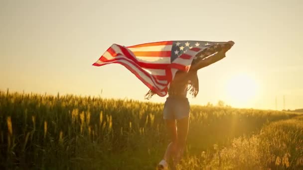 Patriot american woman holding stars and stripes against sky in slow motion — Stock Video