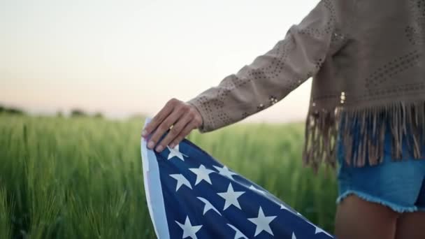 Primo piano vista posteriore mano delle donne con bandiera nazionale USA su spighe di grano. — Video Stock