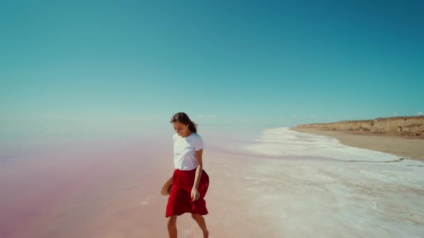 Mujer corriendo por el horizonte infinito espacio vacío en el lago rosa durante el viaje de verano — Vídeos de Stock