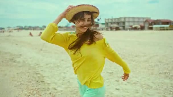 Retrato mulher expressão feliz com cabelo soprando vestindo camisa amarela se divertindo na praia e correndo alegremente — Vídeo de Stock