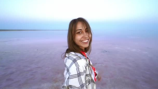 Feliz mujer gozosa disfrutando del paisaje natural en el lago de sal rosa por la noche — Vídeos de Stock