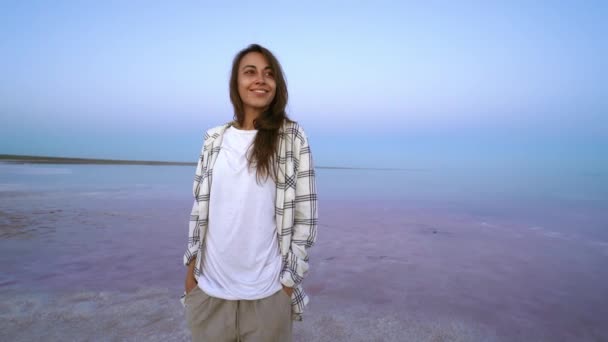 Boldog örömteli nő élvezi a természet táj rózsaszín só tó este — Stock videók