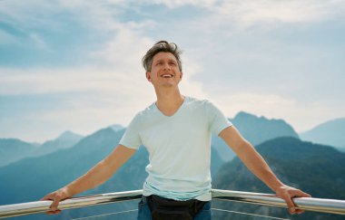 Neşeli gezgin yukarı bakar ve özgürlüğünü hisseder dağların tepesinde.