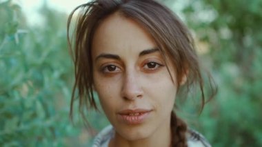 Hippi esmer kadının yakın çekimi, doğal insan yüzü, açık tenli, sakin kameraya bakın ve kendinize güvenin..