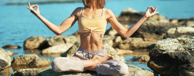 Kadın vücudunu nilüfer çiçeğiyle yoga yaparken, el hareketiyle dışarıda Mudra pozu verirken kapatın.