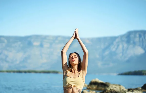 Woman doing morning yoga session process meditation practice with mountains landscape