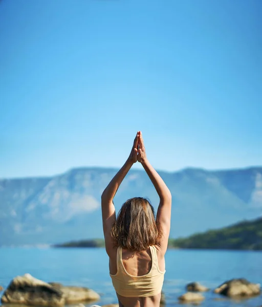Vista posterior de la mujer practica yoga en la naturaleza con hermosas montañas — Foto de Stock
