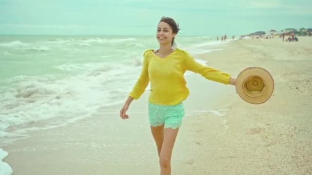 Portrait happy expression woman with blowing hair wearing yellow shirt having fun on beach and joyfully running — Stock Video