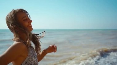 Kumsalda koşan bikinili neşeli fitness kızının yavaş çekim görüntüleri.