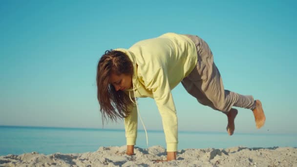 Yoga and Meditation outdoors. Yoga woman by the sea practicing on a beach at sunrise. — Stock Video