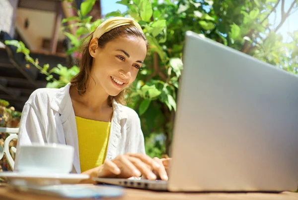 Kveldskvinne som jobber og skriver på bærbar datamaskin, jobber på kafe i ferien – stockfoto