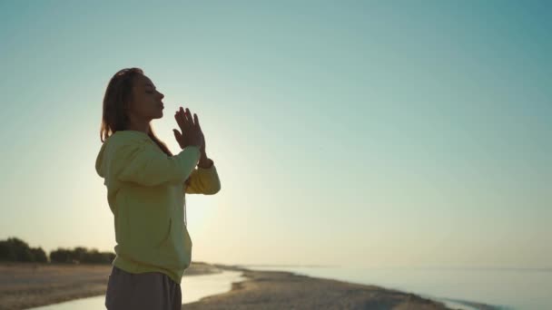 Krásná soustředěná smíšená závodnice Praktiky Správné dýchání a meditace jógy při východu slunce na pozadí modré oblohy. Koncepce zdravého životního stylu — Stock video