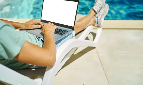 Side View mies työskentelee kannettavan tietokoneen tyhjällä näytöllä, kädet kirjoittamalla tekstiä näppäimistöllä — kuvapankkivalokuva