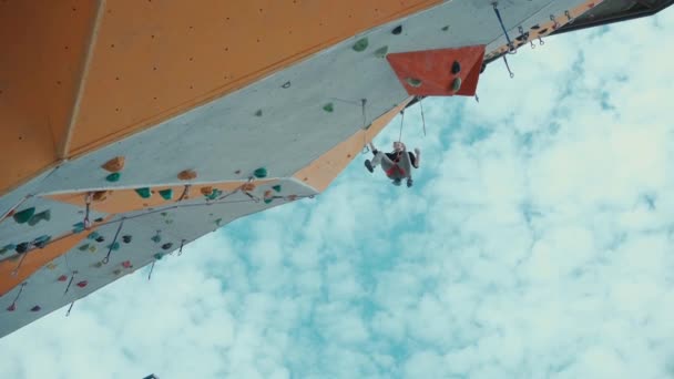 Arrampicatrice ragazza appesa alla corda dopo la caduta dalla via impegnativa sulla parete della palestra di arrampicata all'aperto. — Video Stock