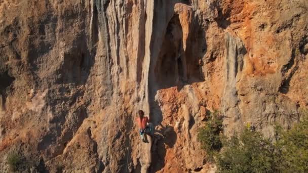 Kireçtaşı uçurumundaki zorlu yolun başarılı tırmanışından sonra uzun saçlı dağcının yavaş çekim görüntüleri.. — Stok video