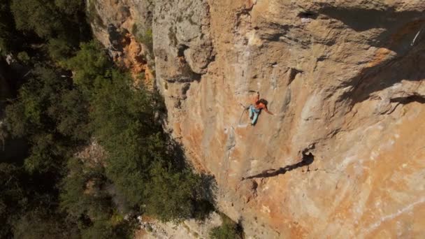 Luchtbeelden. uitzicht vanaf drone van sterke gespierde man klimt uitdagende rotsklimroute op verticale kalksteen crag — Stockvideo
