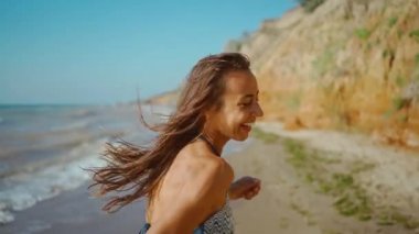 Kumsalda koşan bikinili neşeli fitness kızının yavaş çekim görüntüleri.