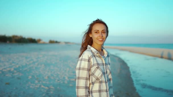 Retrato al aire libre de mujer de raza mixta atractiva feliz disfrutando de la puesta de sol en la playa de arena marina salvaje con luz solar roja en la cara — Vídeo de stock