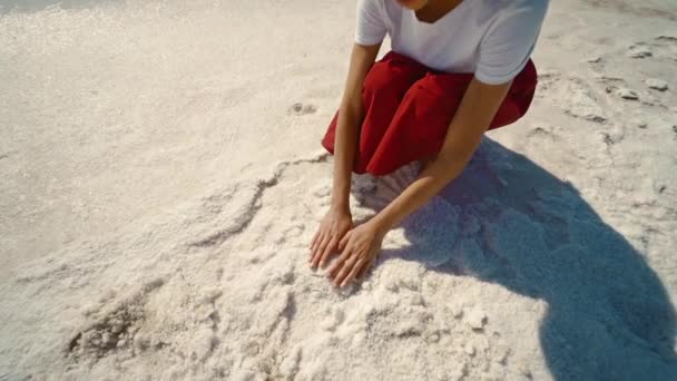 Close-up slow motion beelden van vrouwen voeten en handen op droge kust van zout mineraal meer. — Stockvideo