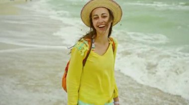 Özgürlük portresi. Sarı tişörtlü, gülen kadın. Deniz kenarında tatil yapıyor, kendini iyi hissediyor..