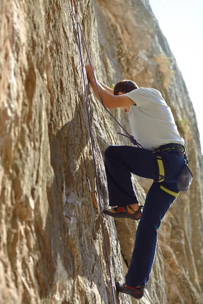 Rock climber climbing up a cliff — Stock Photo, Image